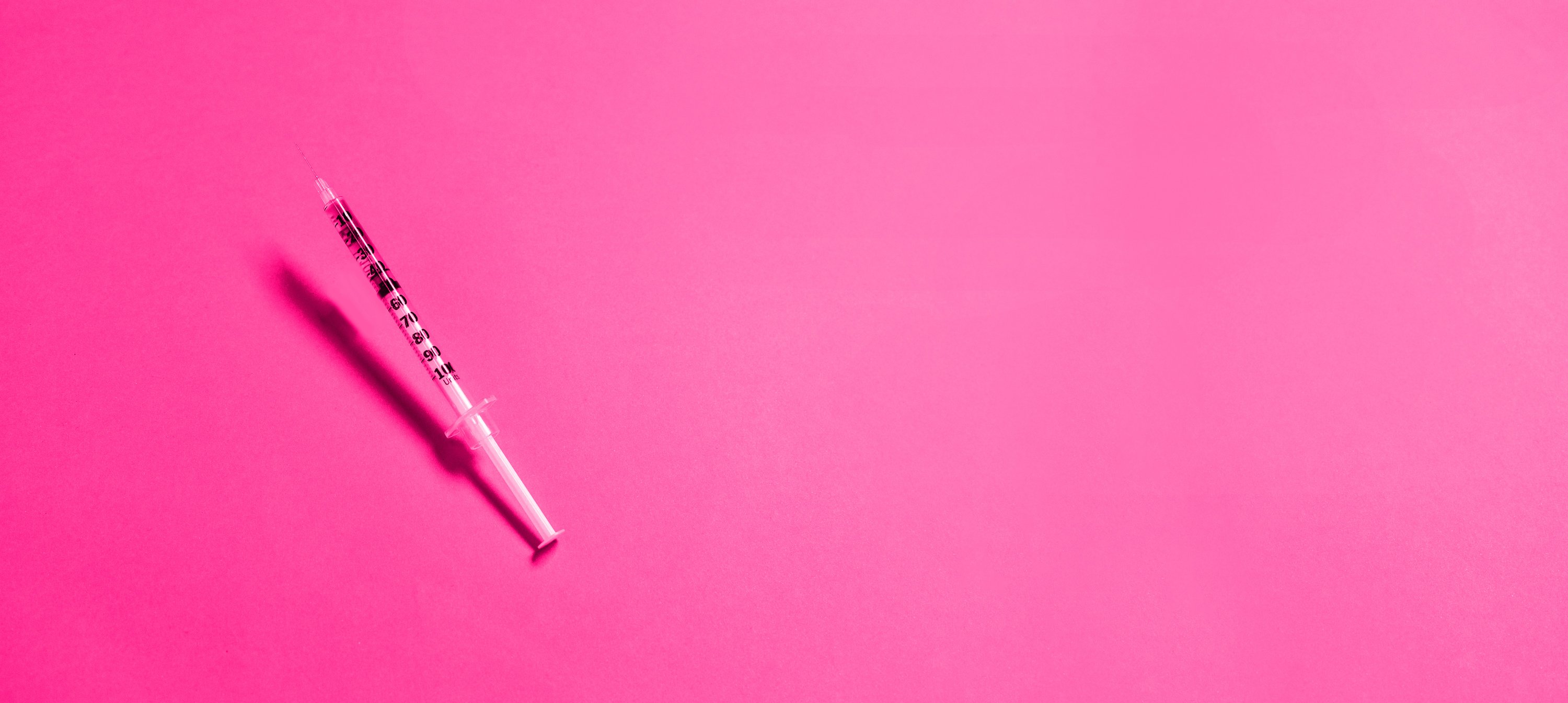 Medical Syringe on Pink Background